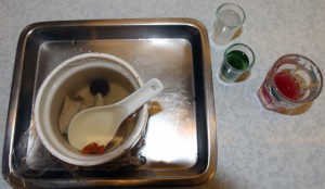 A bowl of snake soup with three alcoholic shots of snake venom (clear), snake gallbladder (green), and snake blood (red).