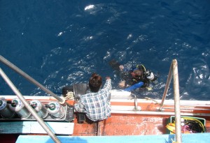 A SCUBA Diver coming back on board the boat.
