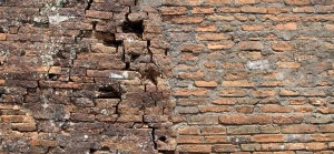 Original bricks stacked and glued on the left and poorly restored bricks cemented together on the right at Mỹ Sơn ruins.