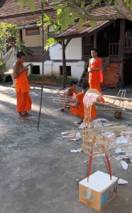Young monks making an airplane effigy in preparation for a Buddhist festival.