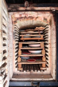 Electric oven loaded with pottery, ready to be cooked.
