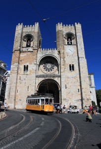 Lisbon Cathedral (officially, the “Patriarchal Cathedral of St. Mary Major”) with a Tram 28 car passing in front.