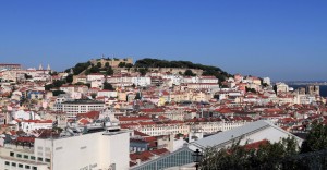 View of São Jorge Castle with the Lisbon Cathedral visible on the right and the Rossio Railway Station in the foreground.