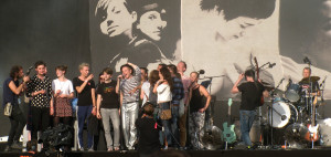 The lead singer of Belle & Sebastian surrounded by audience members he invited on stage to dance with him.